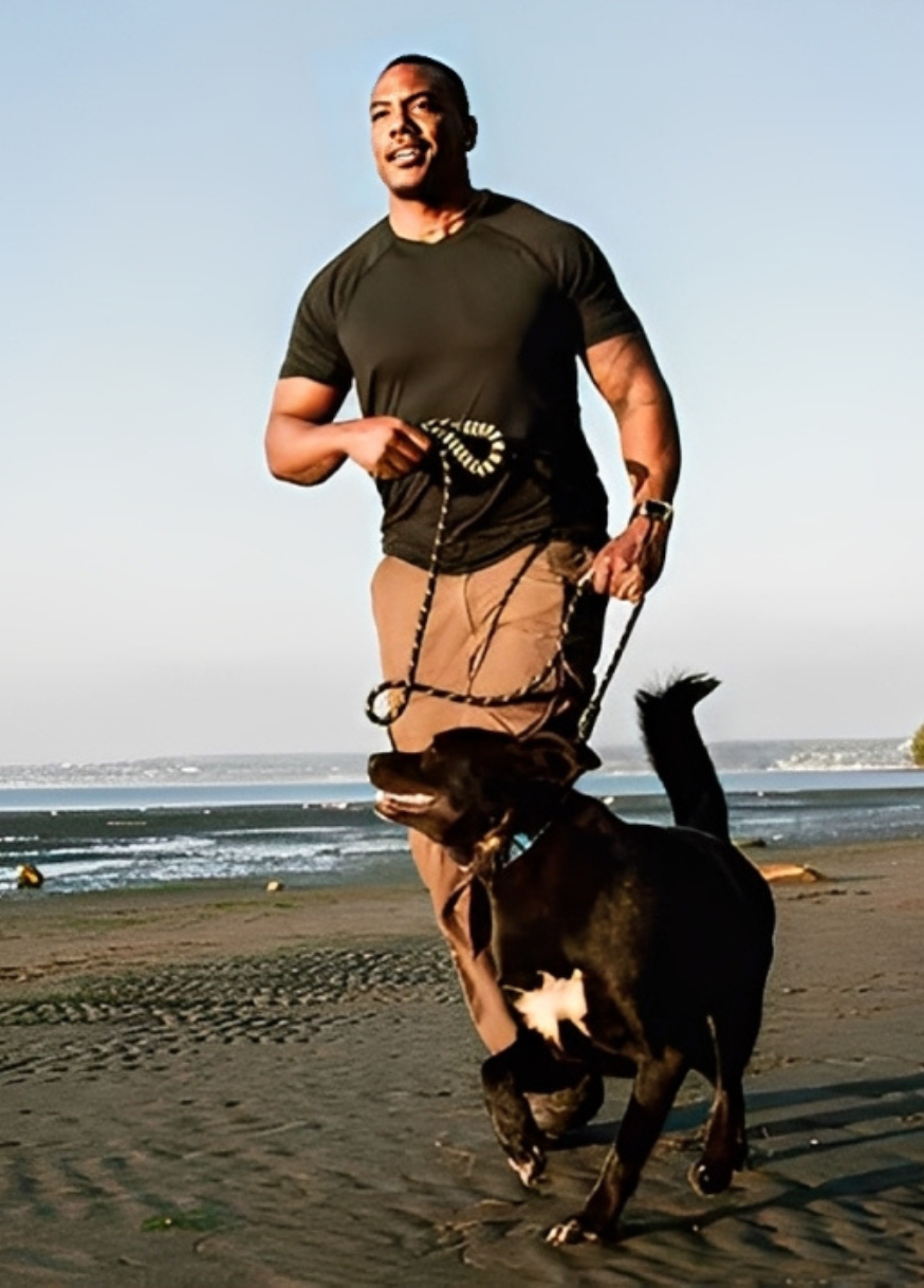 man running dog beach